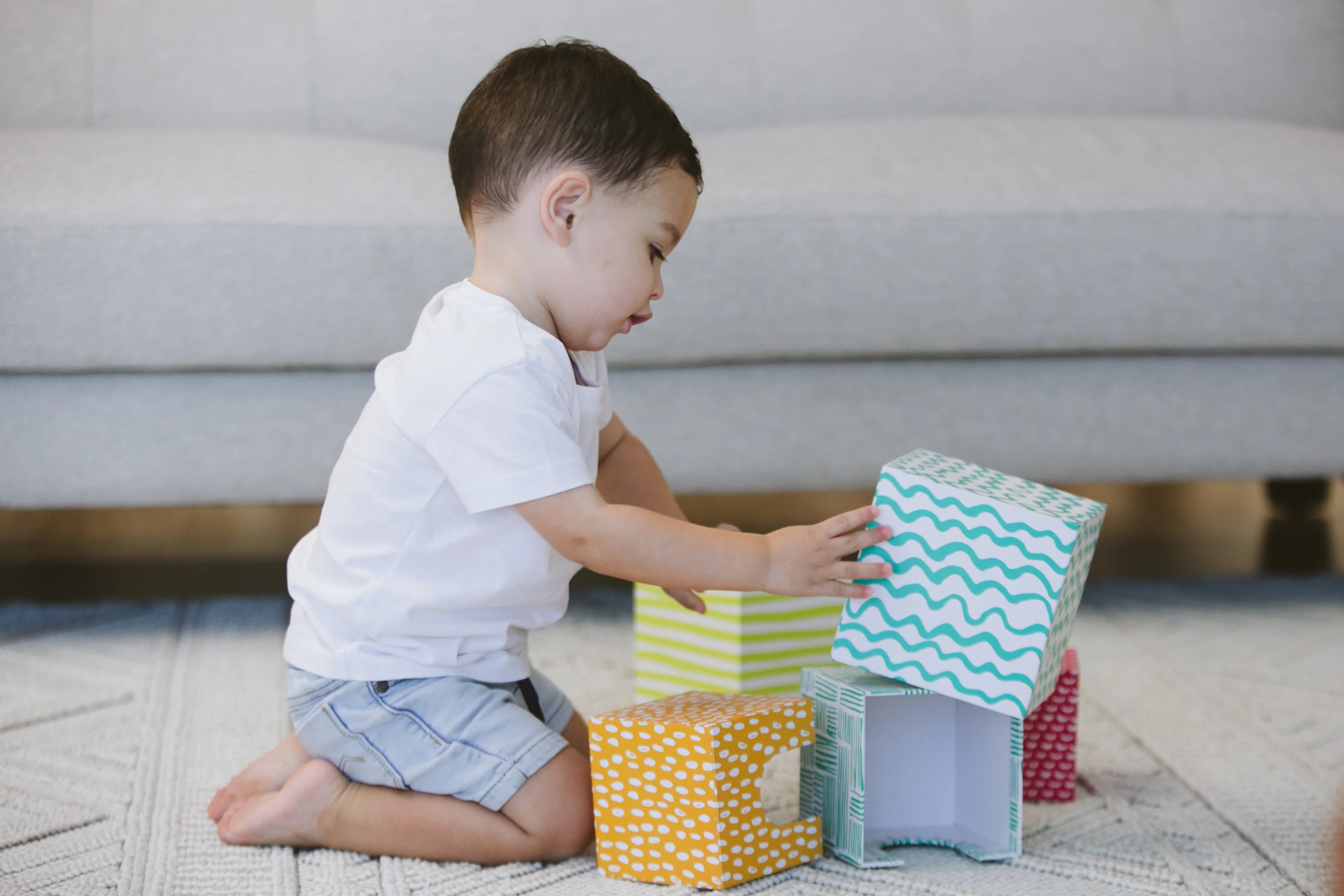 Toddler engaging in a play activity involving connecting objects showcasing their exploration of play schemas.