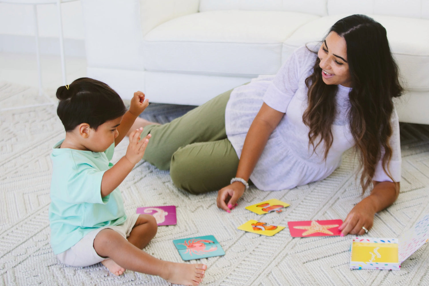 Toddler handing a toy to their mom, practicing language and social interaction skills.