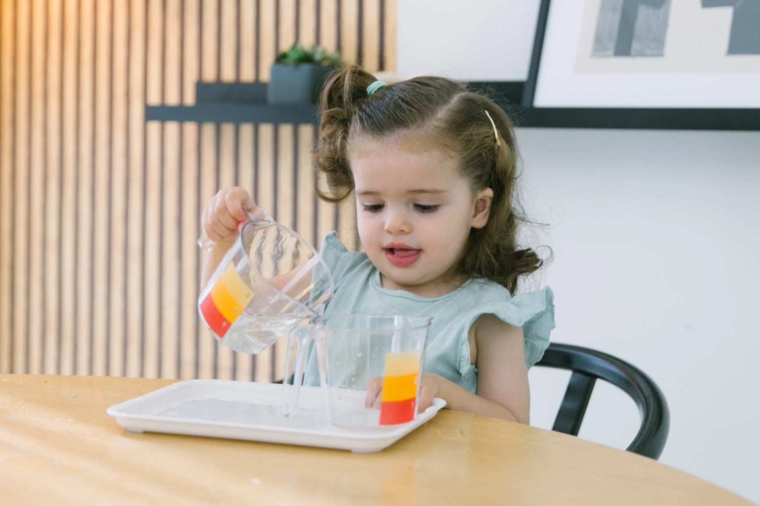 Child exploring a toy box with various locks and latches, engaging in a Montessori-inspired activity that promotes fine motor skills and problem-solving