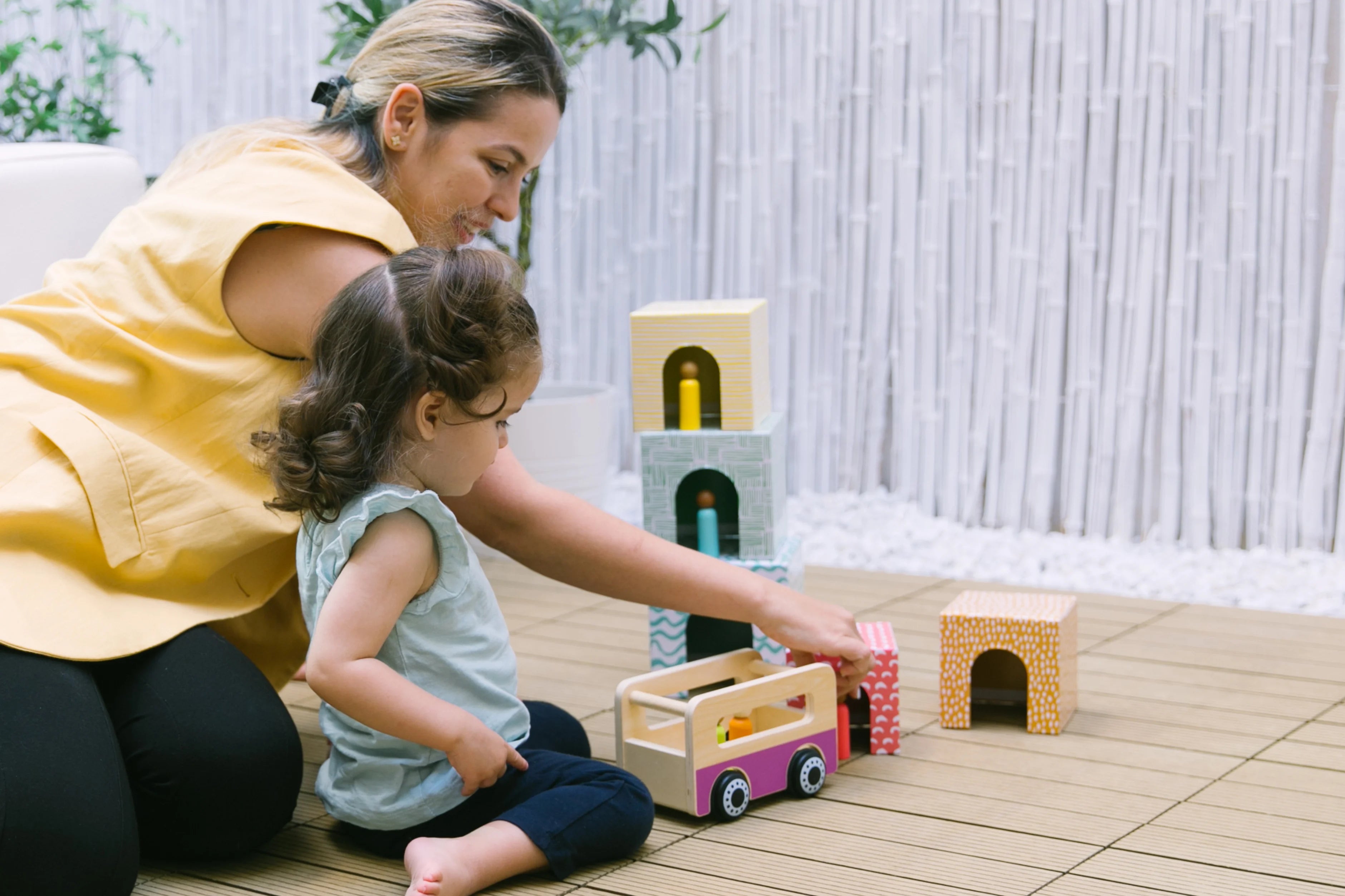 Mom and toddler sitting together and reading a book, engaged in a cozy and interactive reading session that supports language development and bonding.