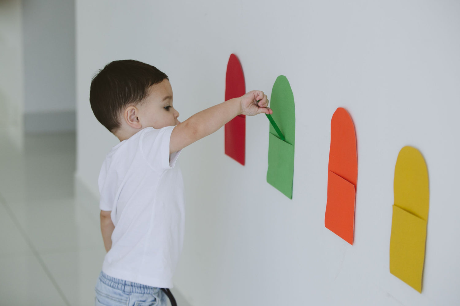 toddler matching colors on wall in a color DIY activity