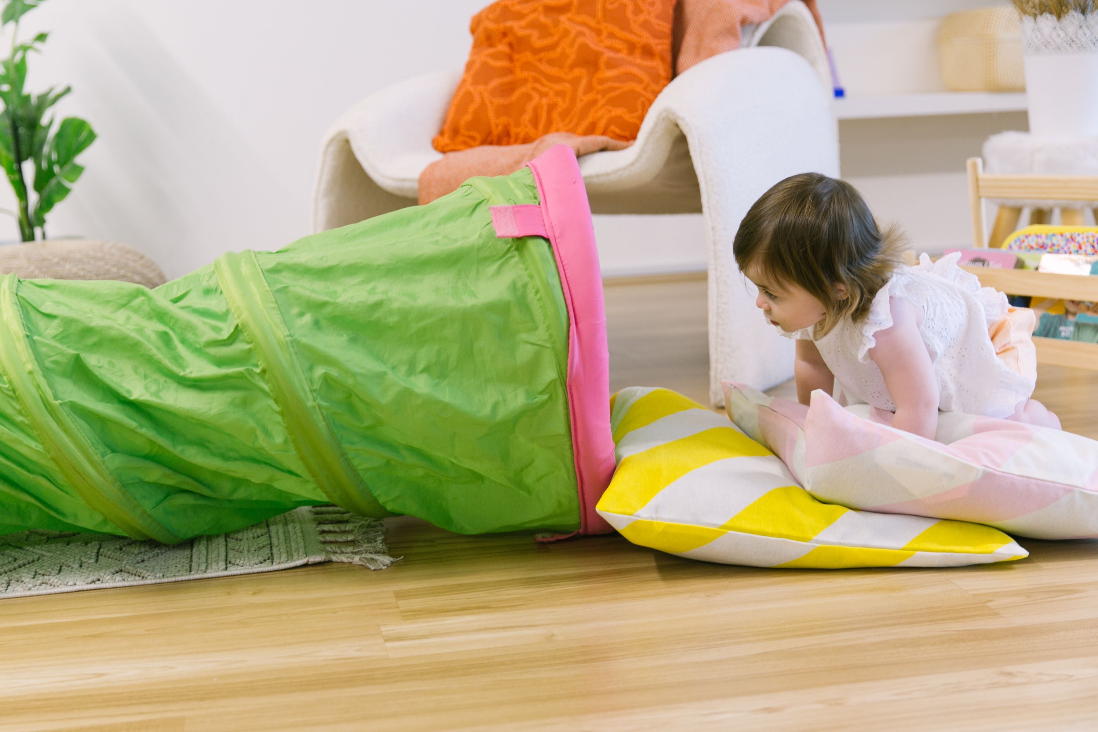 Toddler climbing on a soft cushion tower, engaging in safe and fun gross motor activities